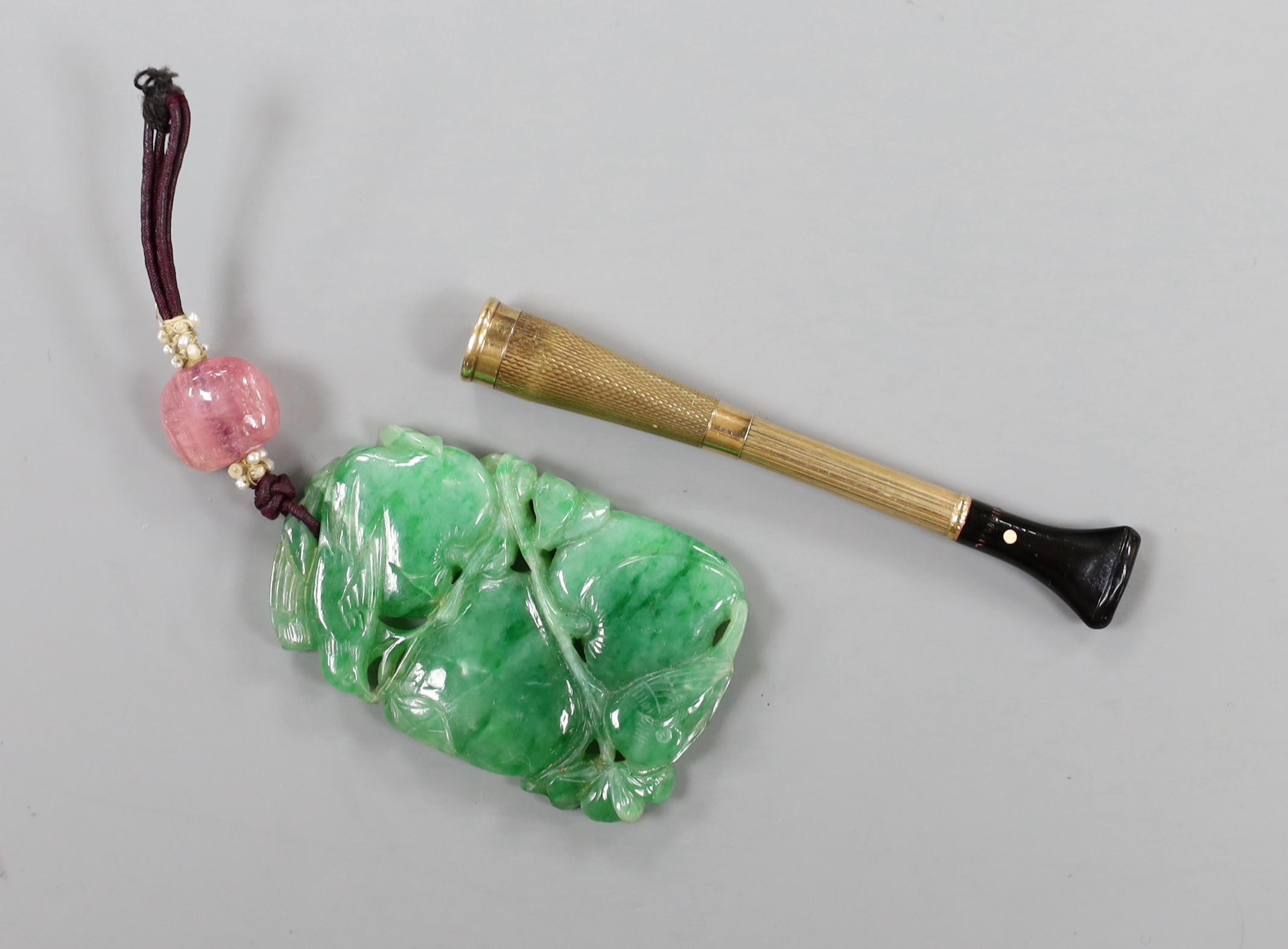 A Chinese carved jadeite pendant and 9ct gold mounted cigarette holder.